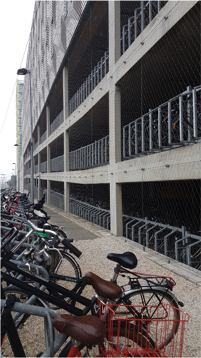 Cykelställ framför parkeringshus i tre öppna plan