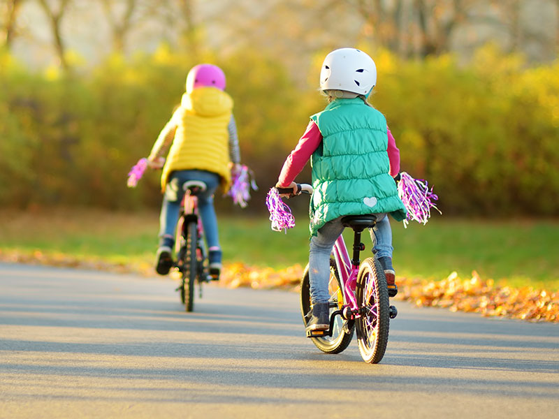 Barn cyklar på hösten