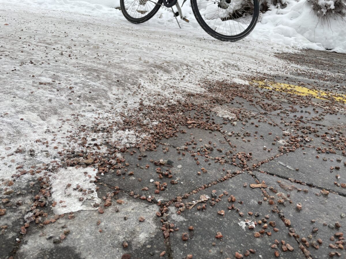 Cykelbana med packad snö och barmark med grus